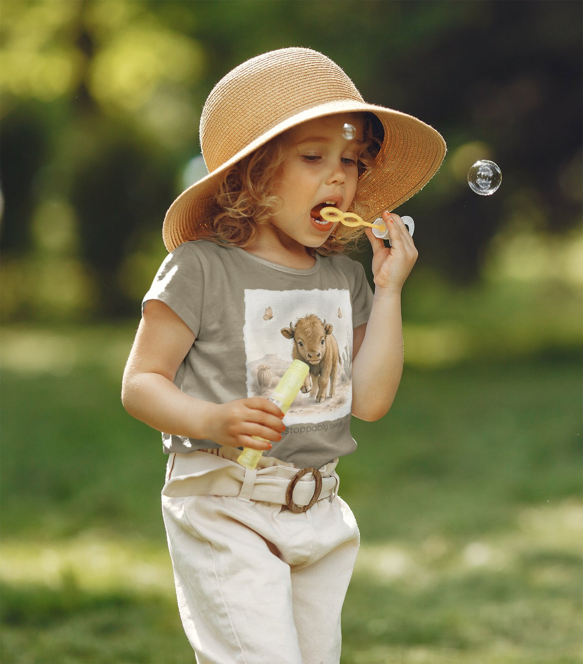 Toddler blowing bubbles wearing the Buffalo tee